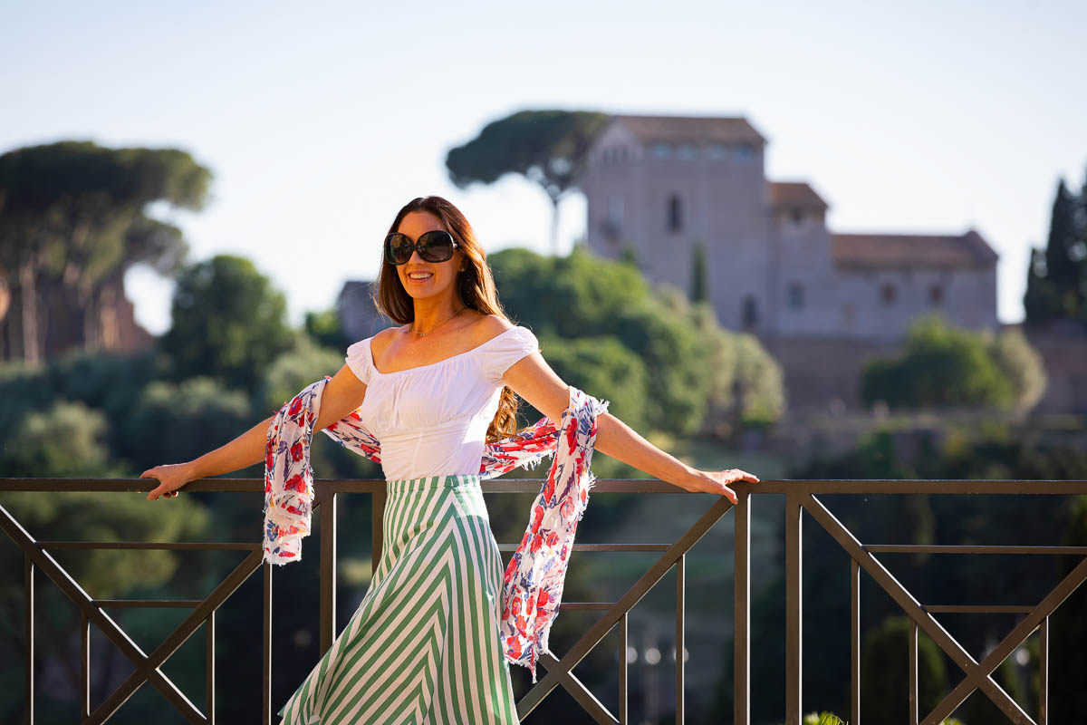 Arms open portrait with roman landscape as backdrop during the golden hour 