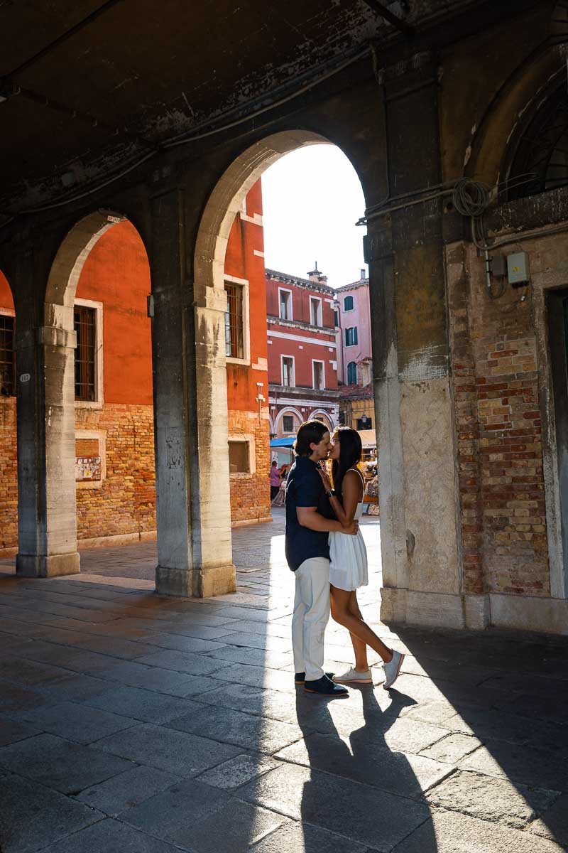 Couple posed underneath porticos during a photoshoot in Venice Italy