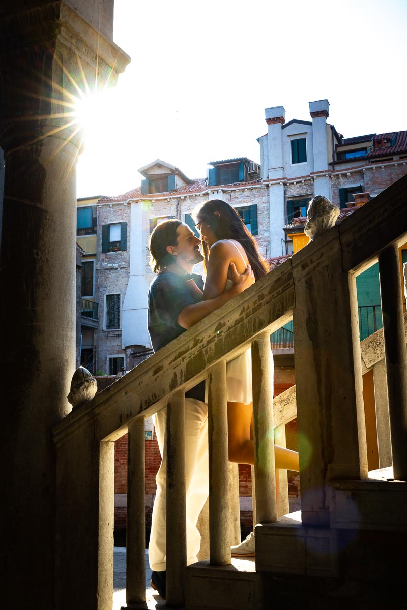Final portrait picture of a couple standing on a staircase with the sun setting in the background