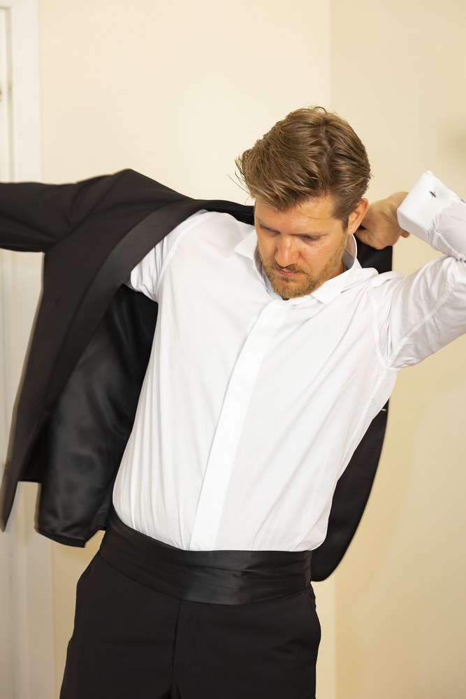 The groom putting his jacket on 