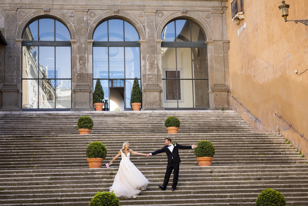 Taking fun and creative wedding pictures of the newlywed couple on the Campidoglio staircase