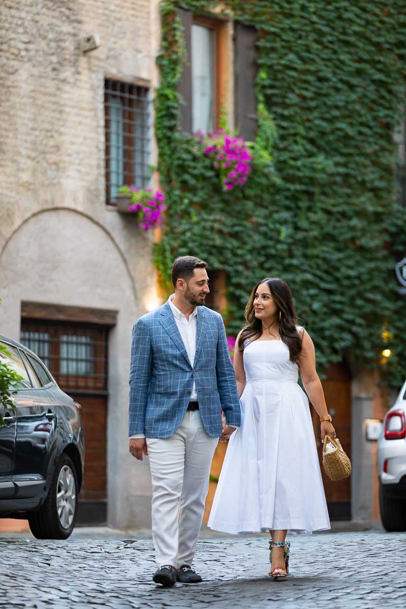 Couple walking hands in hands in the off the beaten track roman cobble stone alleyways 