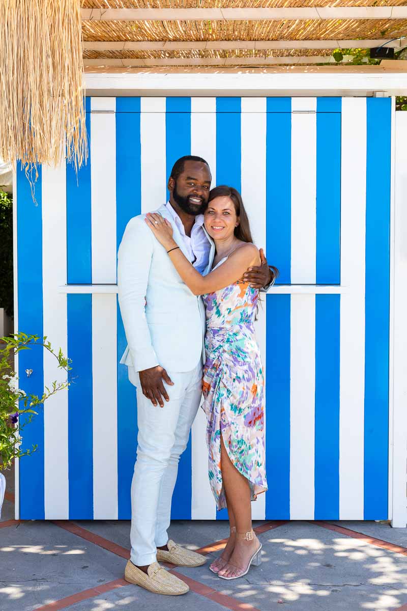 Couple portrait against blue and white changing cabins so typical of the Amalfi coast 