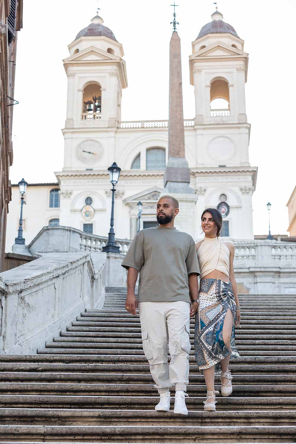 Couple holding hands and walking down the Spanish steps in Rome Italy