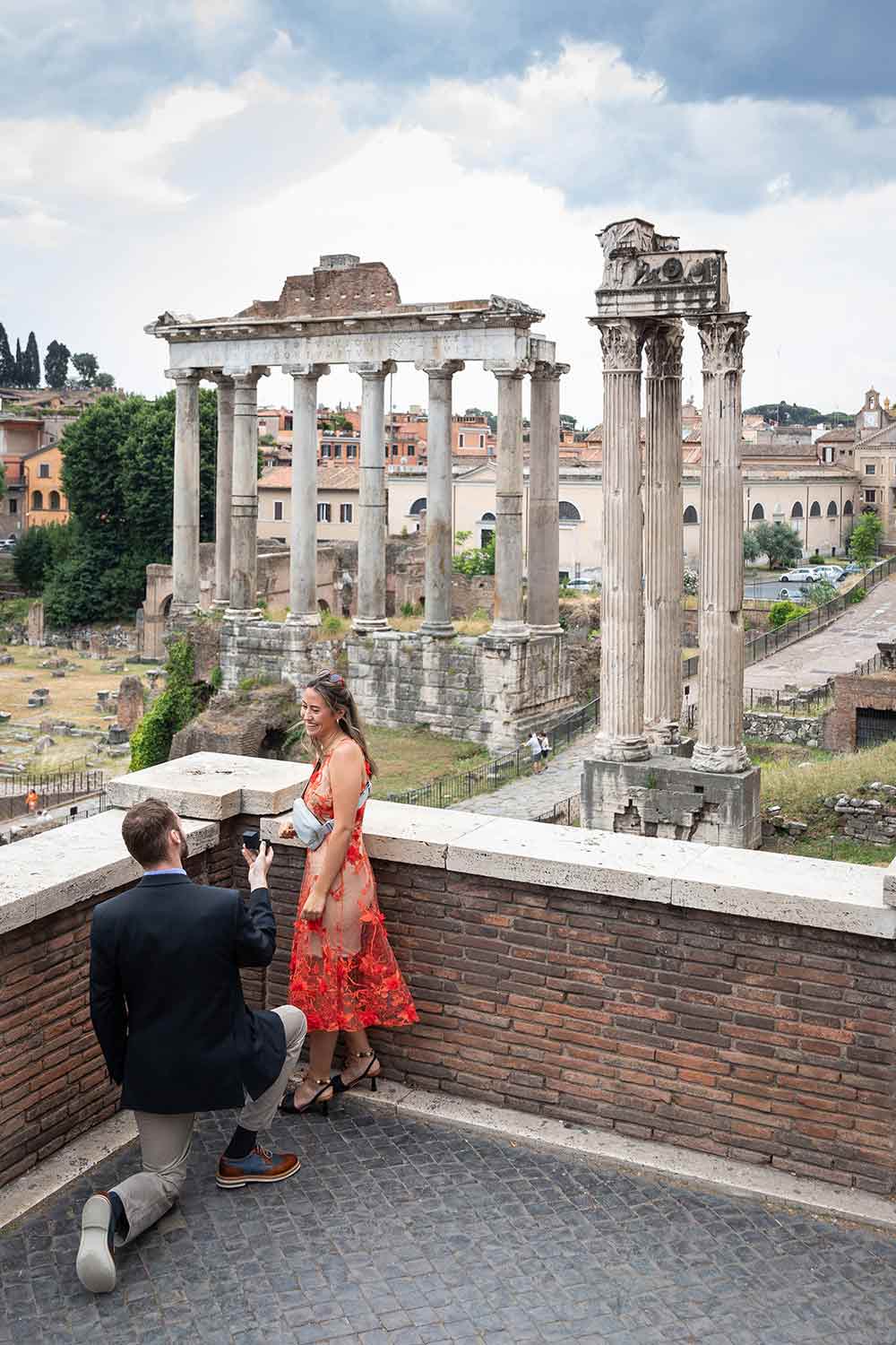 Roman Forum Proposal. Surprise Wedding Proposal candidly photographed from Piazza del Campidoglio in Rome overlooking the ancient forum monuments from a distance 