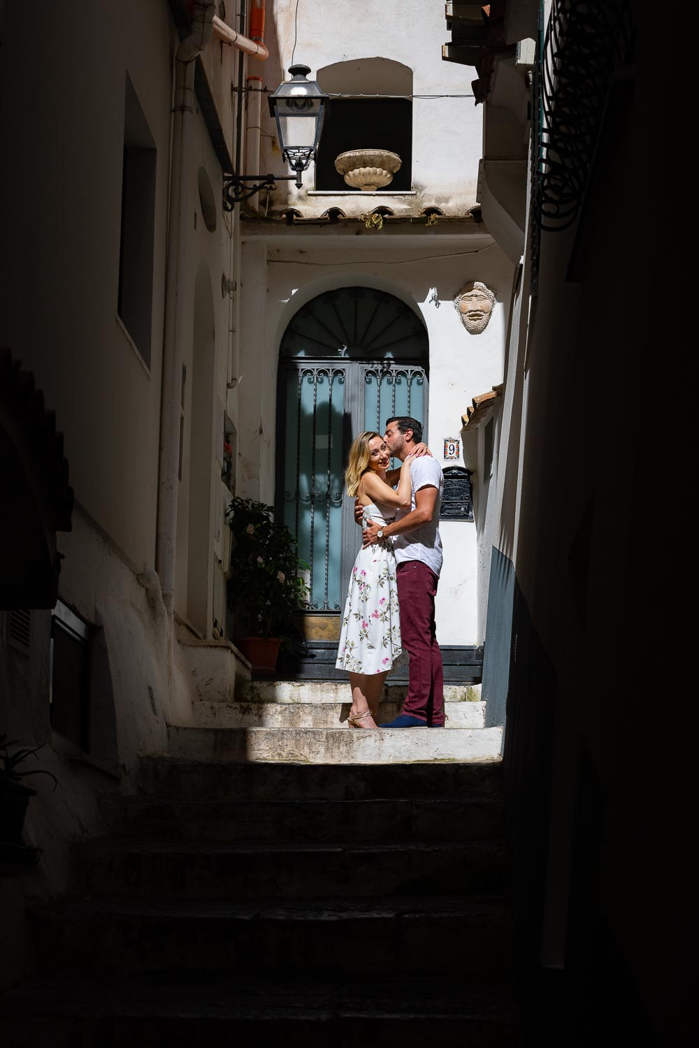 Together taking pictures in the alleyway streets in a picket of light among building shadows 