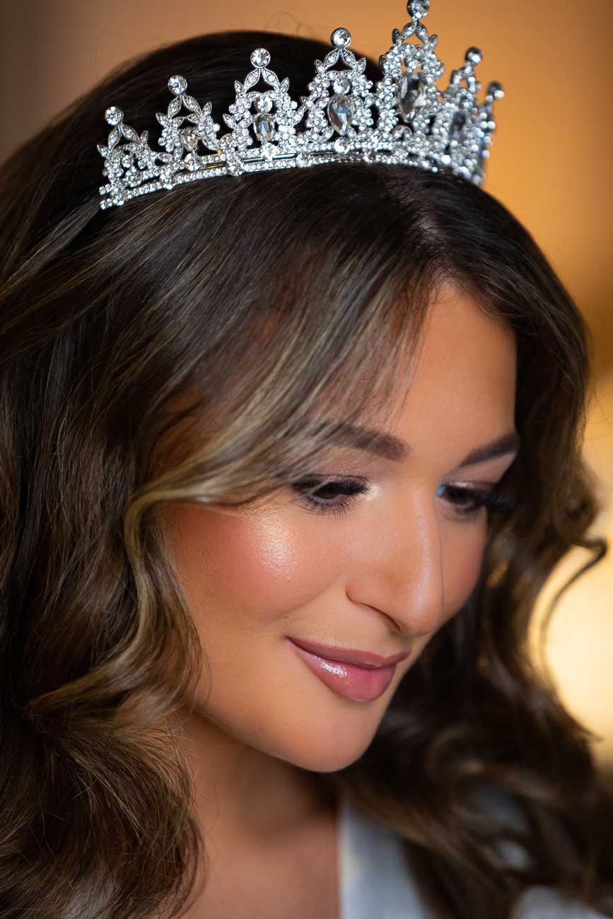 Bride portrait wearing a bridal crown and posing for a picture during the hair and make up service