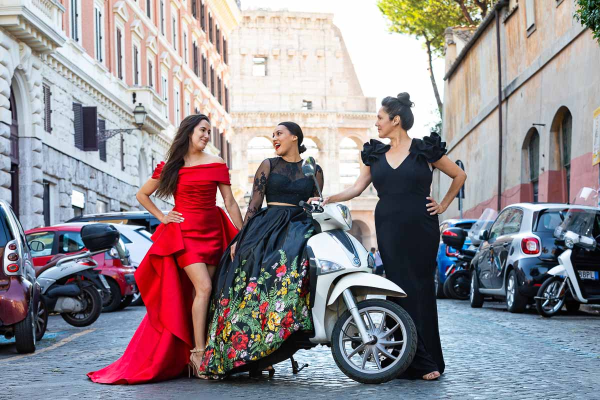 Group family picture taken with a Piaggio Liberty scooter on a cobblestone alleyway before Rome's Colosseum