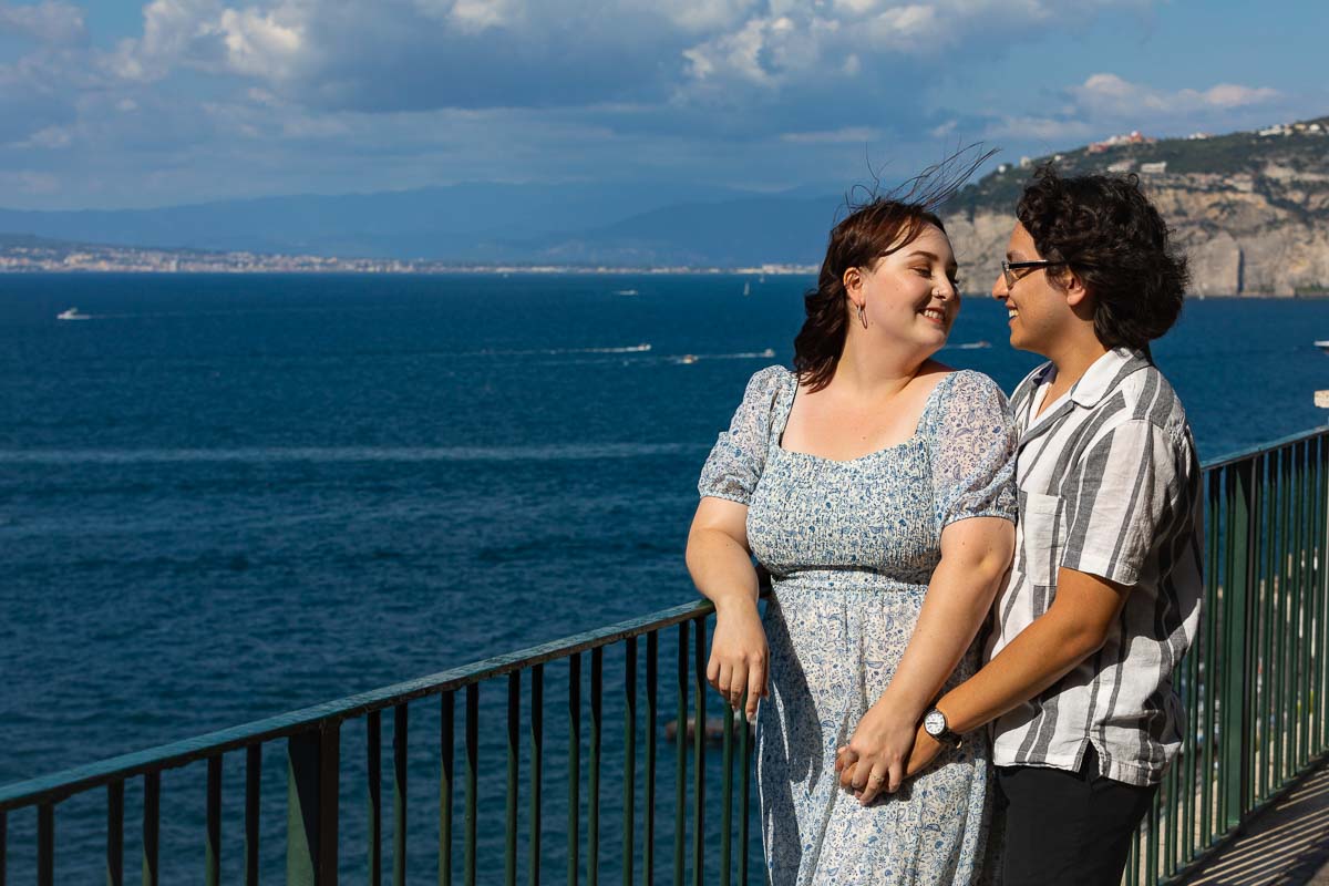 Couple together on the Sorrentino coast overlooking the Mediterranean sea with the city of Naples in the far distance and the Vesuvio vulcano in the background