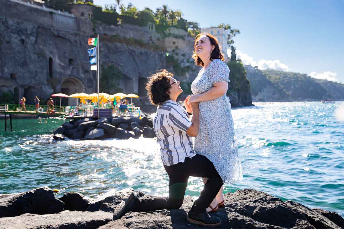 Proposing by the sea water overlooking the Amalfo coast in the far distance 