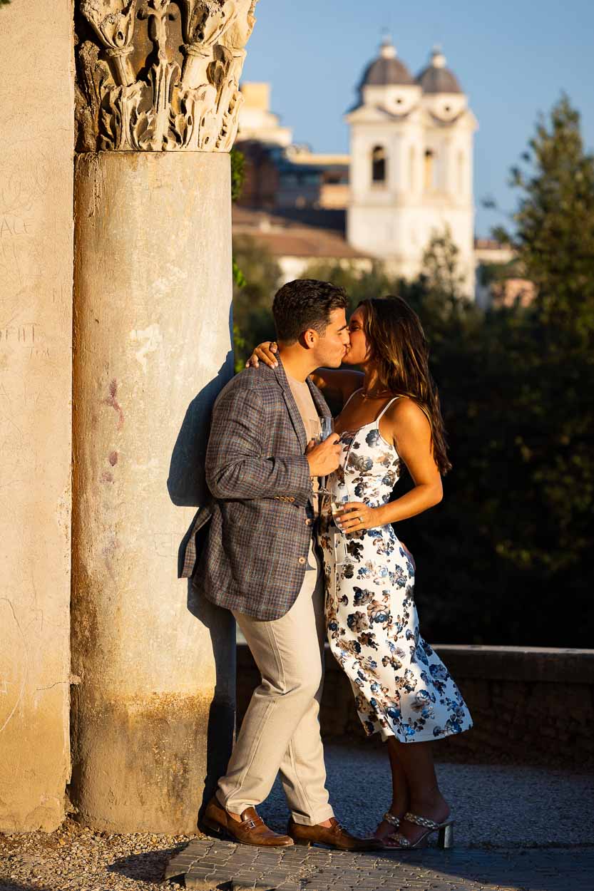 A romantic moment photographed during a photoshoot in Rome Italy. Kissing while leaning into an ancient roman column