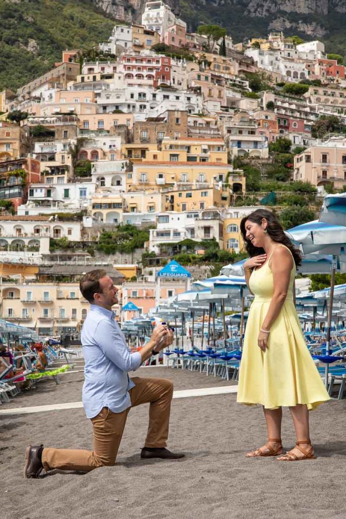 Asking for her hand on the beach of Positano with the vertical town in the background