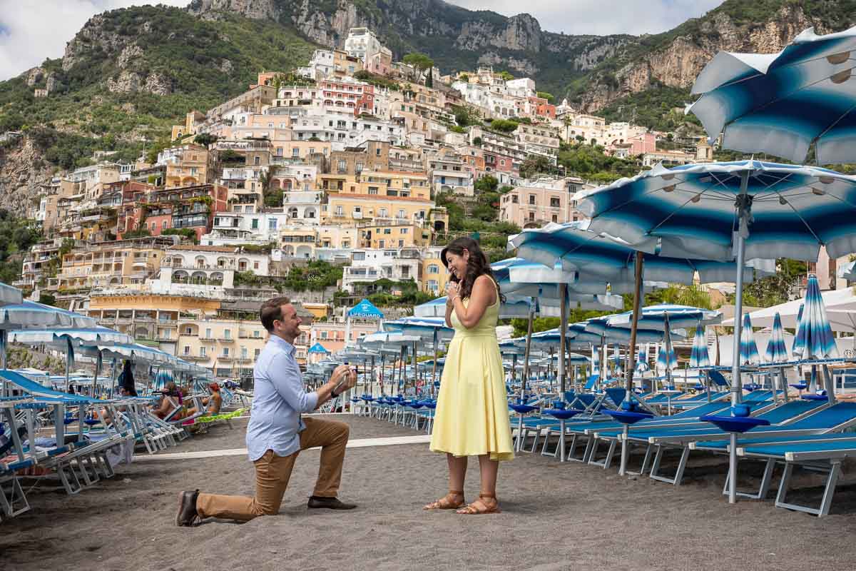 Proposing under beach umbrella on the beach sand. Amalfi Proposal in Positano