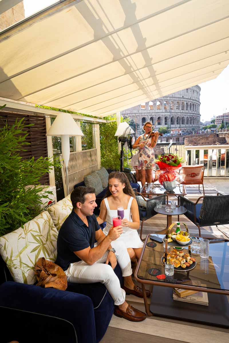 Toasting and celebrating engagement in Rome Italy at a private venue with a unique background view of the Colossem 