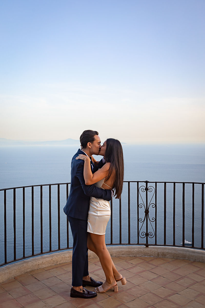 Couple kissing on a terrace overlooking the sea of the Amalfi coast at sundown. Ravello Proposal Photography