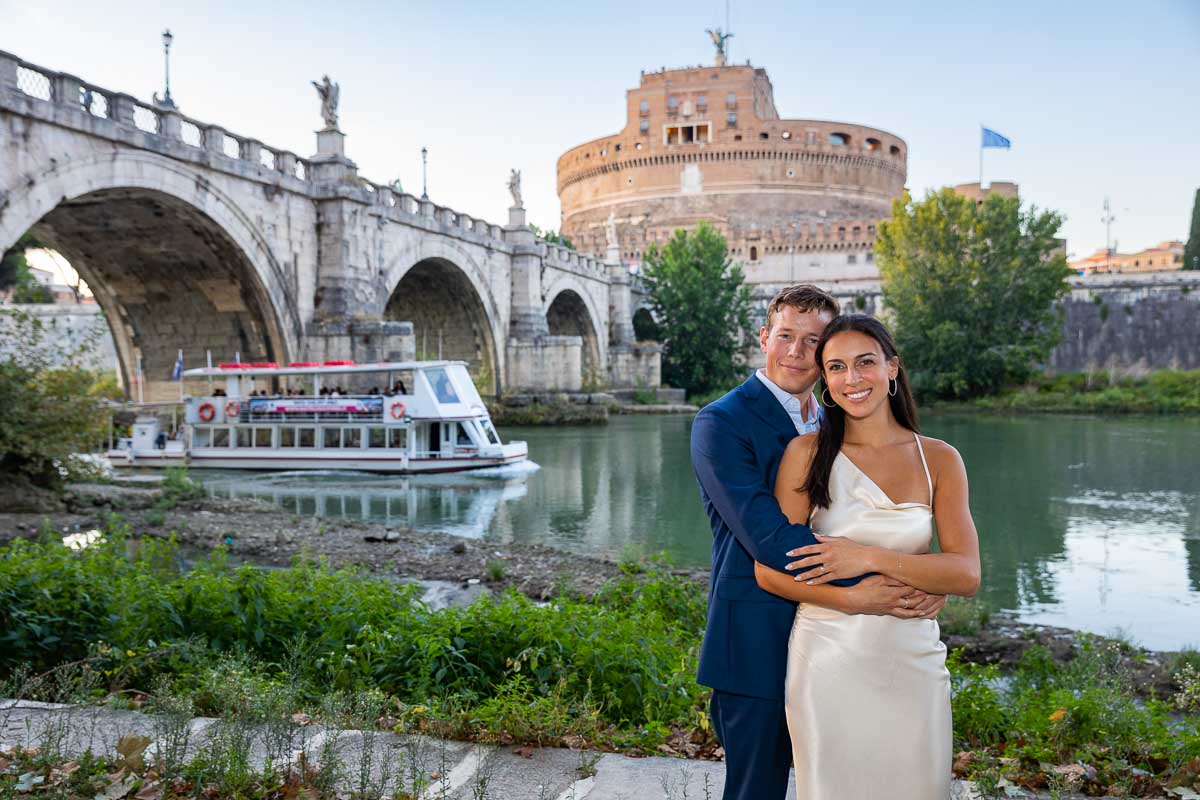 Couple portrait during a photography session in Rome Italy with a local river boat as backdrop