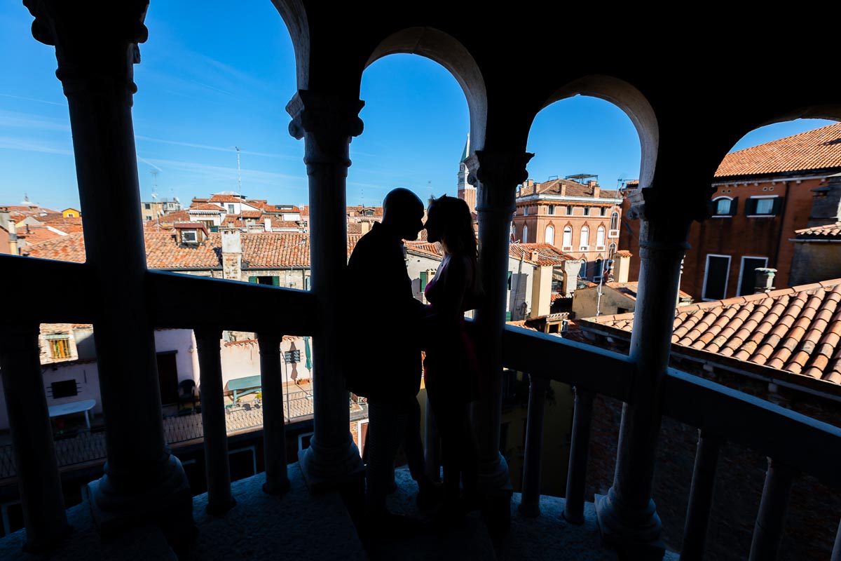 Silhouette image of a couple standing together inside the scalinata Contarini del bovolo staircase 