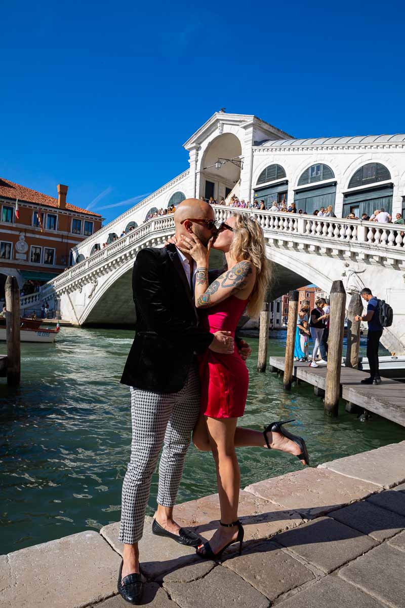 Couple posing and kissing in front of the Rialto bridge in Venice. Italy