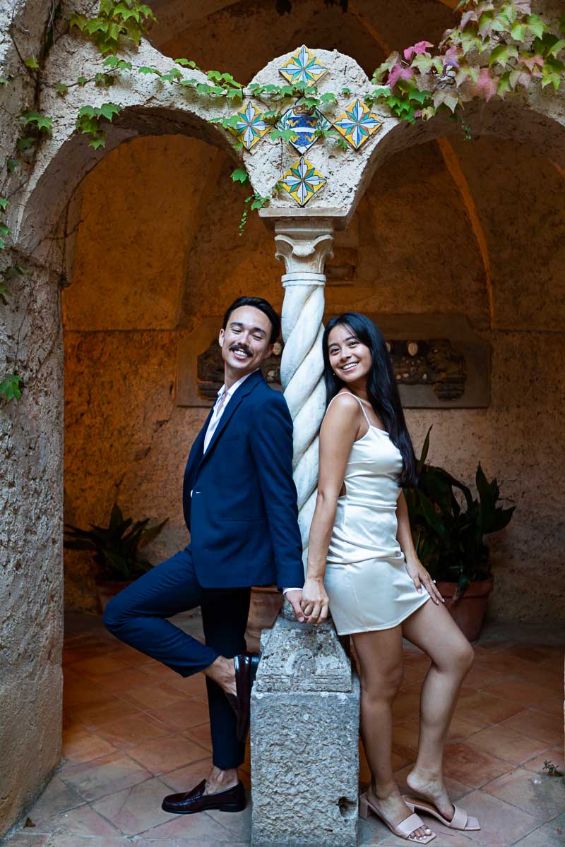 Couple taking engagement pictures leaning into a white marble column