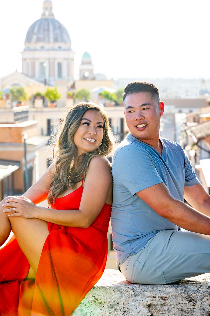 Close up couple picture posed sitting down by a wall overlooking the roman panorama