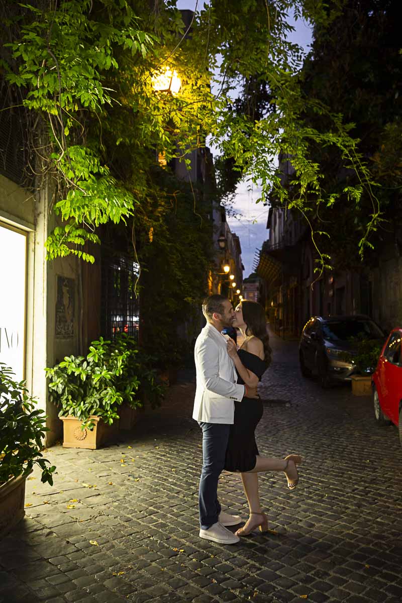 Taking engagement pictures on a cobblestone alleyway street at night 