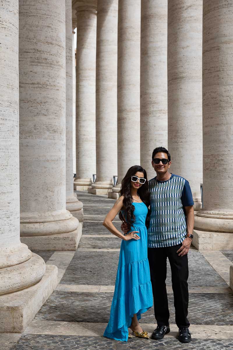 Couple pose under the columns found in Piazza San Pietro in the Rome's Vatican square
