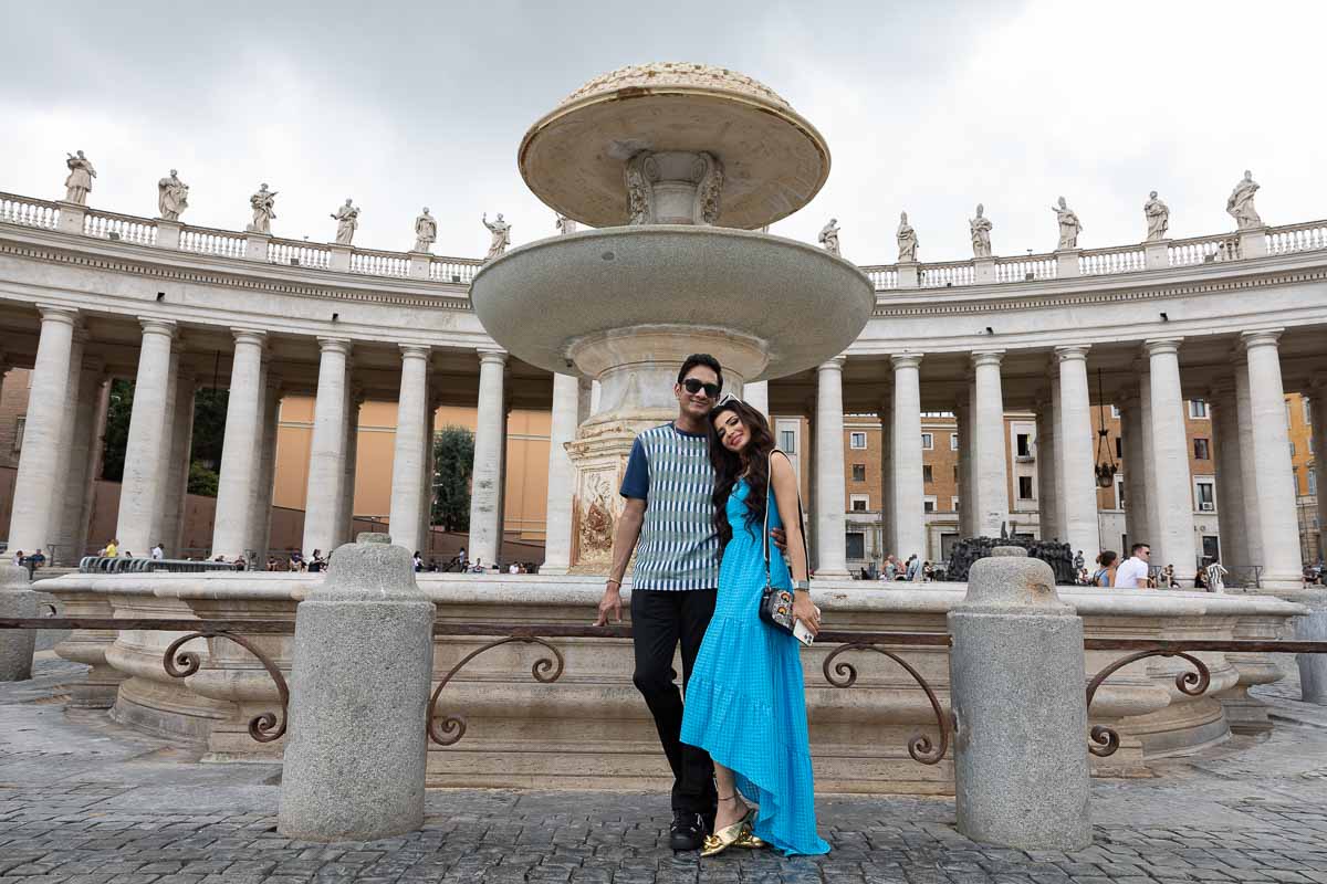 Together in Rome taking pictures in Saint Peter's square next to a water fountain with the colonnade in the background