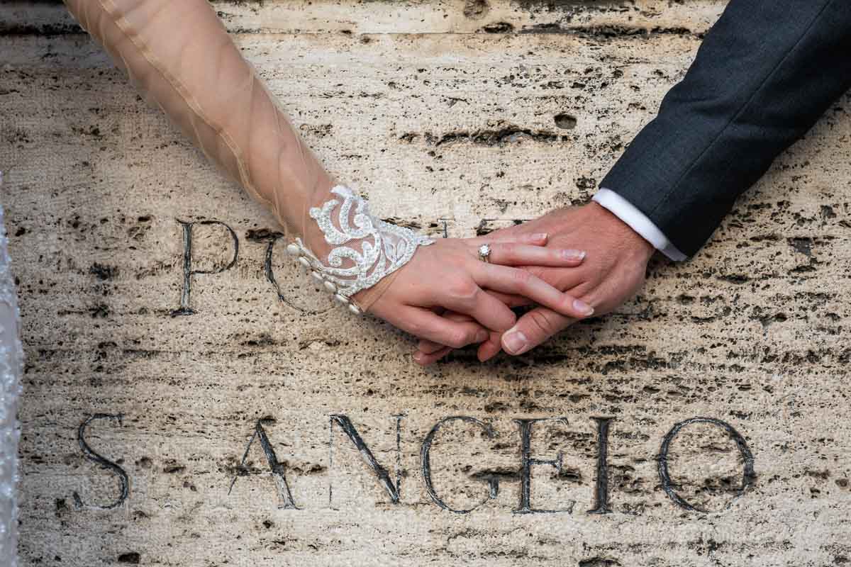 Picture of the wedding rings photographed over the ancient encryption of Ponte S. Angelo in Rome Italy 