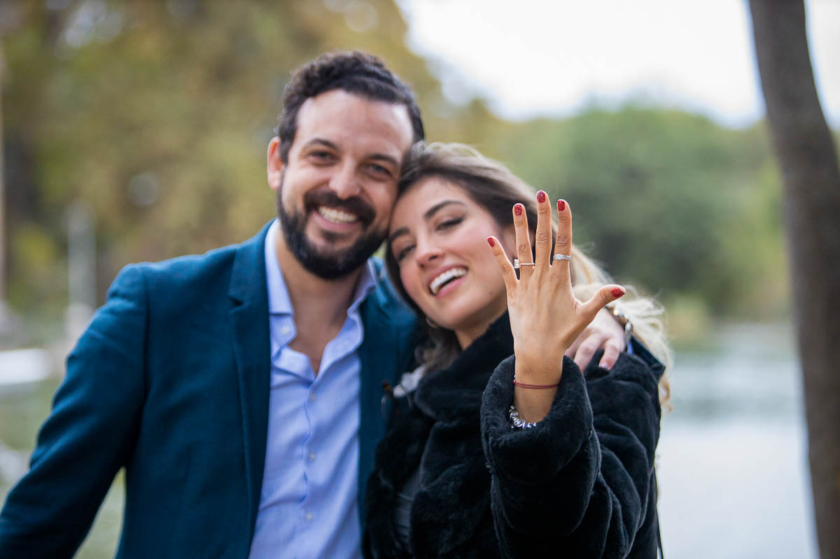 Couple holding up the engagement ring in celebration of the wedding proposal 