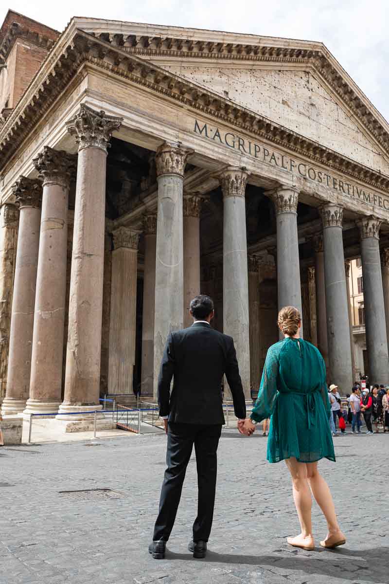 Couple holding hands and admiring the Roman Pantheon from Piazza della Rotonda. Rome. Italy