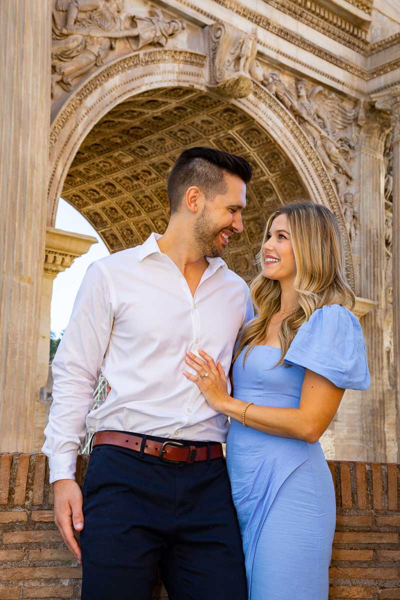 Posed portrait of a couple standing framed around an ancient roman arc