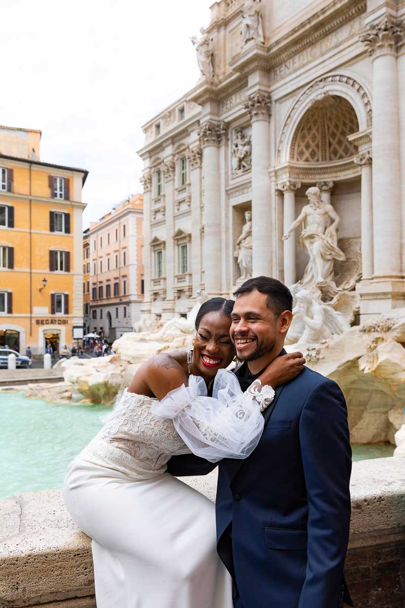 Laughing and having fun at the Trevi fountain during a wedding photoshoot in Rome