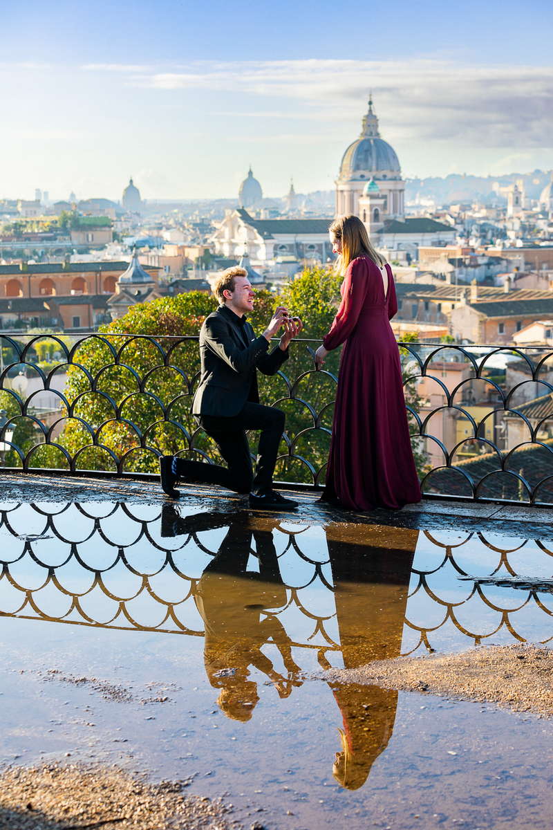 Knee down wedding marriage proposal photographed at Parco del Pincio. With a beautiful water puddle reflection which gave the photo extra atmosphere