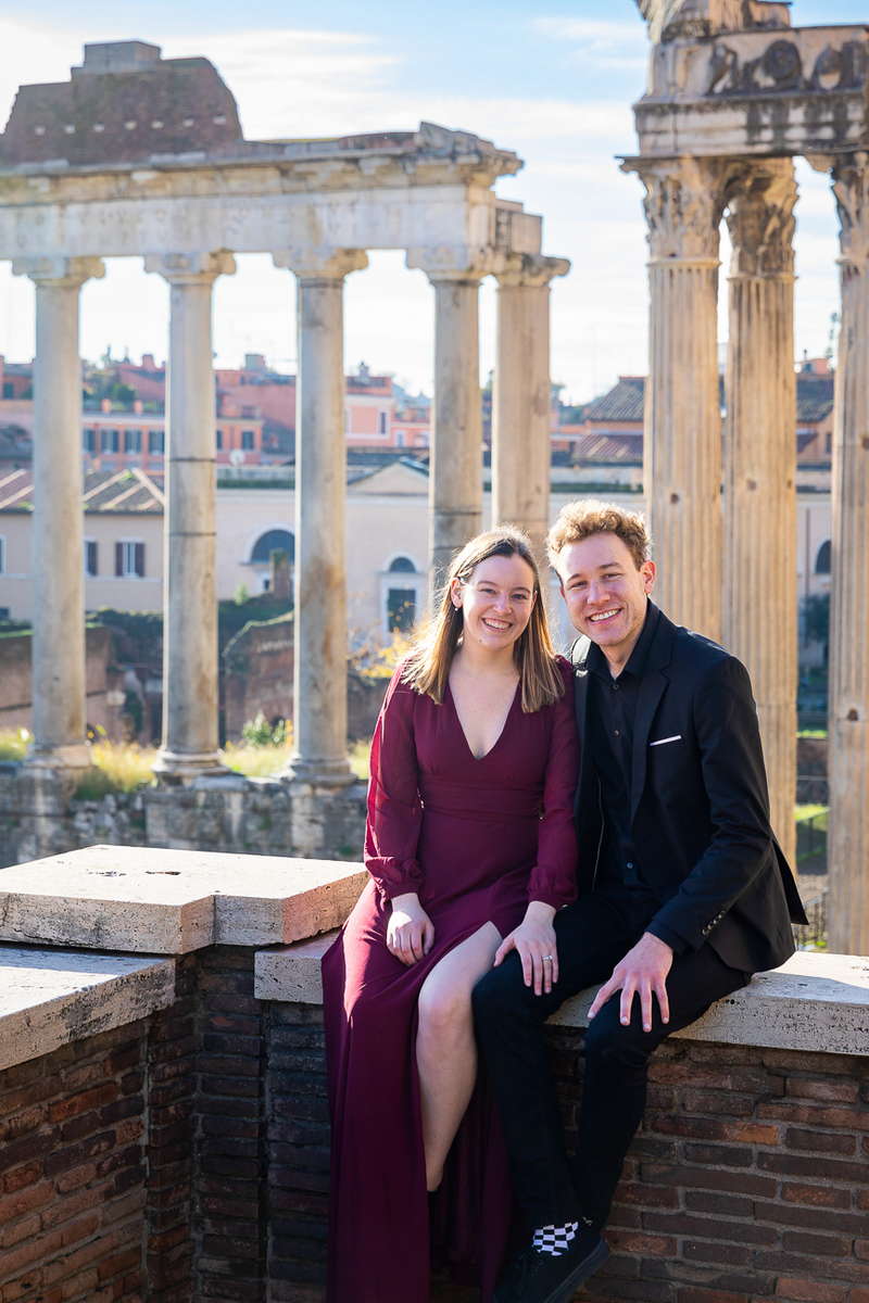 Couple portrait sitting down before an ancient temple at the roman forum 