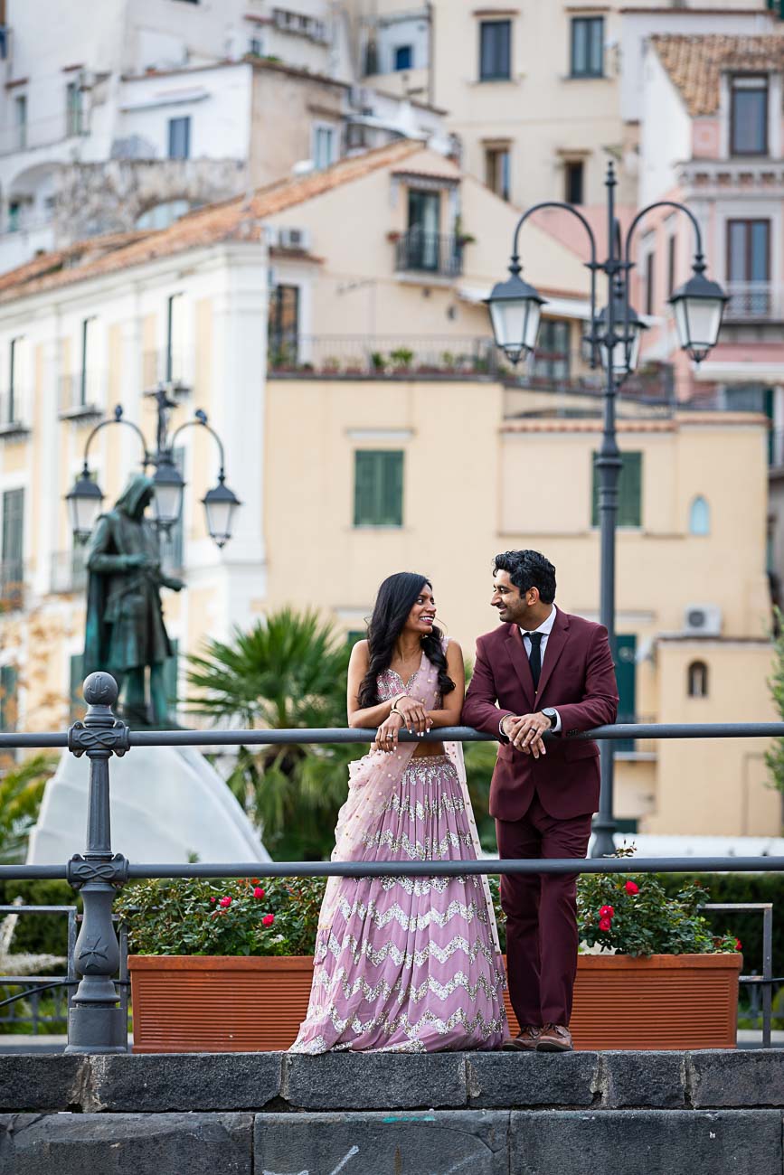 Town photos in Amalfi while leaning on the railing talking and smiling