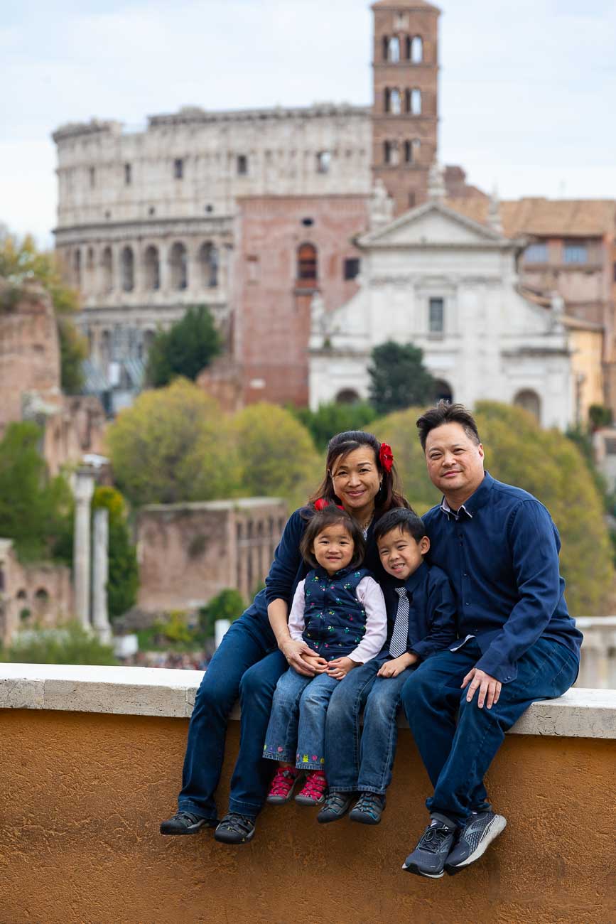 Family portrait picture photographed taken in front of the distant view of the Roman Colosseum