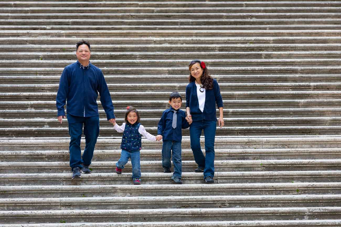 family walking hand in hand as they walk down a staircase