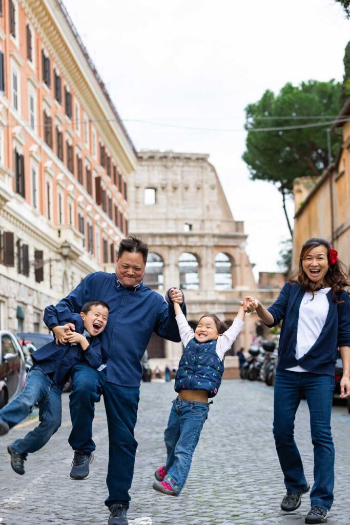 Fun family picture taken in Rome Italy while walking on a cobblestone alleyway leading to the Roman Colosseum in the far distance