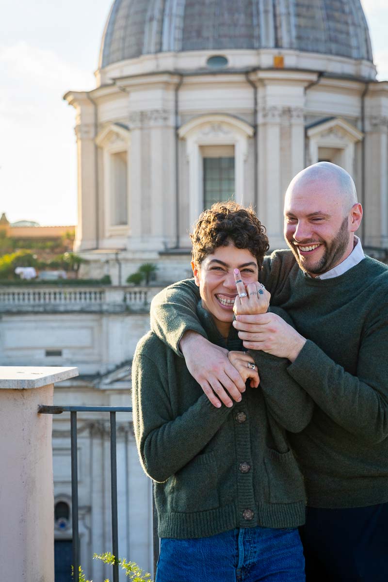 Couple showing the engagement ring after a surprise wedding marriage proposal candidly photographed in Rome Italy