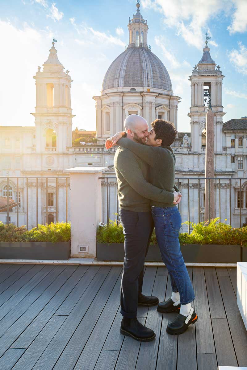 Couple just engaged on a terrace in Rome Italy overlooking a beautiful church in the background at sunset
