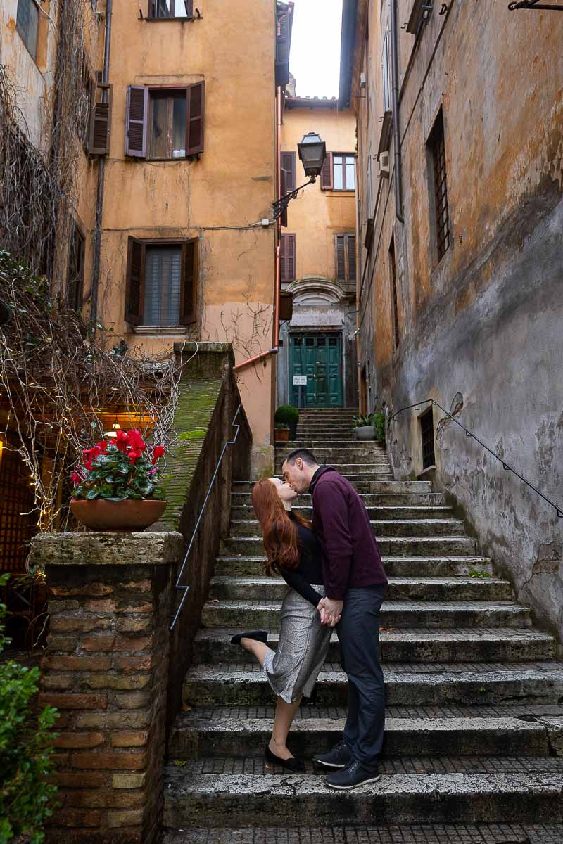 Couple kissing on a set of staircase found in the cobble stone streets of Rome 