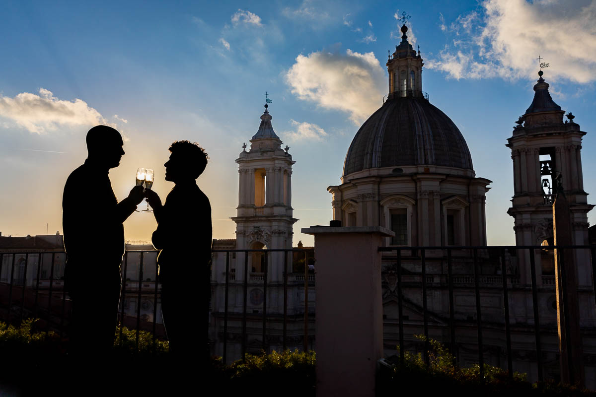 Silhouette image of a couple celebrating and toasting engagement with a bottle of prosecco Italian wine 