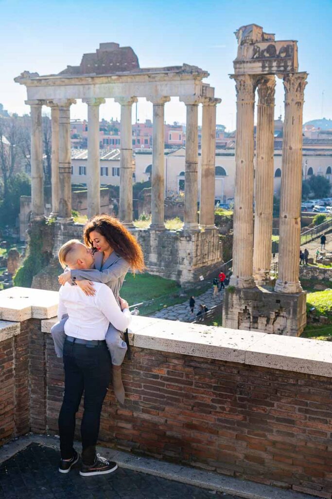 Couple portrait image sitting down before the ancient roman ruins