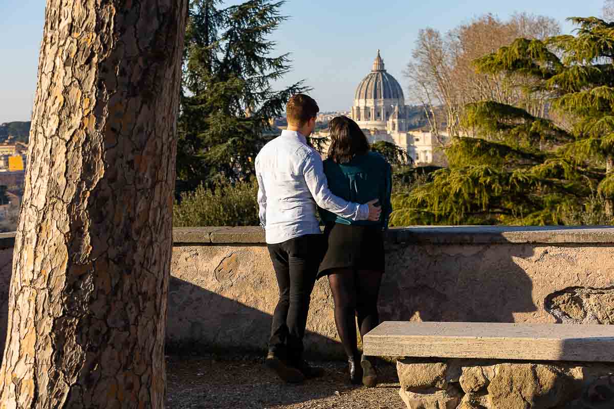 Couple admiring the view of Saint Peter's dome in the far distance during their engagement photos
