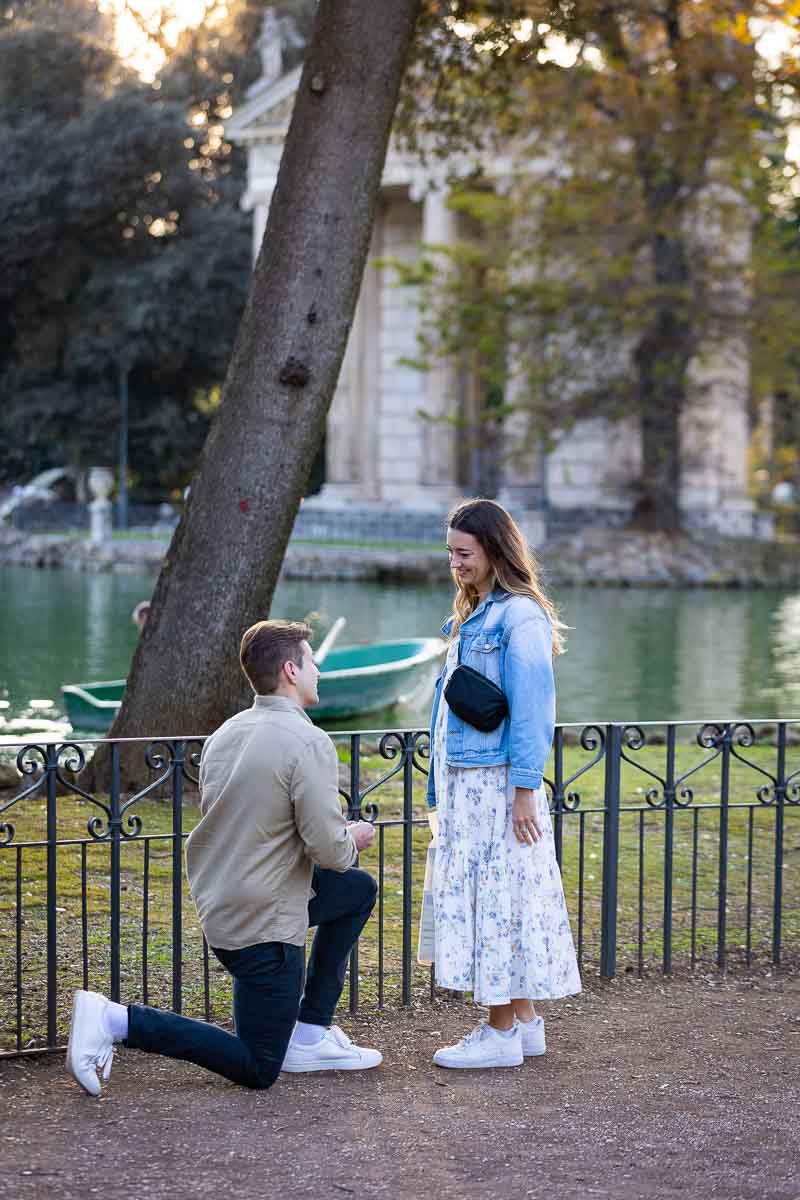 Surprise Wedding Marriage Proposal candidly photographed from a distance at the Villa Borghese lake in Rome Italy