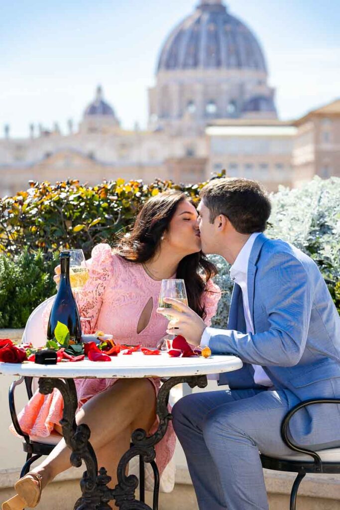 Couple kissing at a romantic table with an exclusive view of Rome's Saint Peter's basilica
