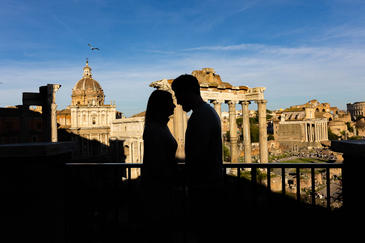 Silhouette picture of couple standing close together in front of the Roman forum 
