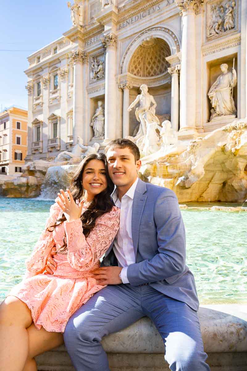 Sitting on the edge of the Trevi fountain showing off the new engagement ring