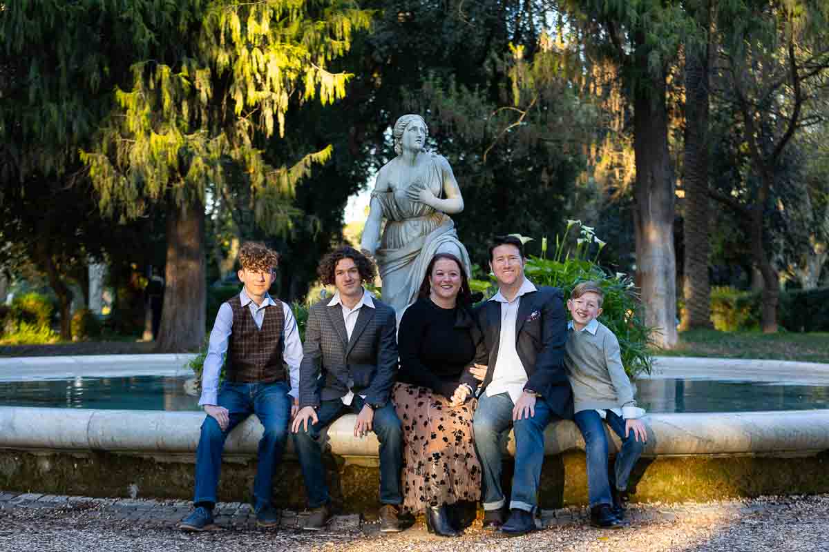 Sitting down photo gathered around a circular water fountain in Villa Borghese