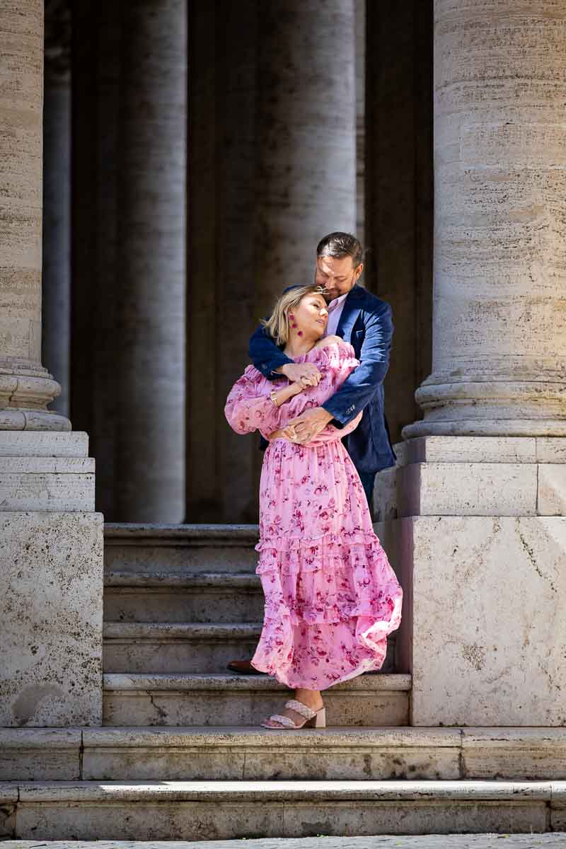 Portrait picture of couple standing in between ancient marble columns. Rome, Italy.